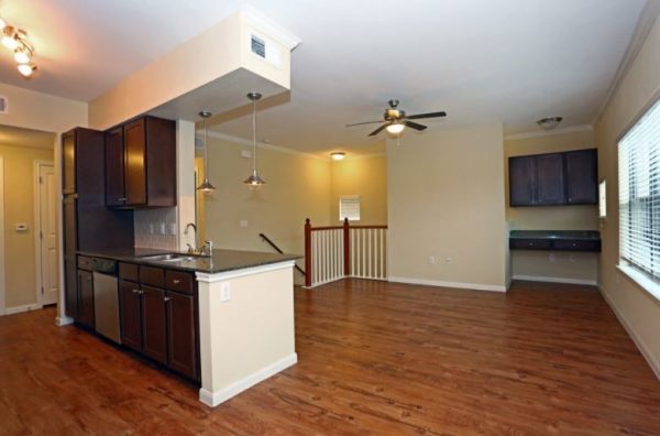 Unfurnished apartment overview with kitchen and stairs to the lower level in view