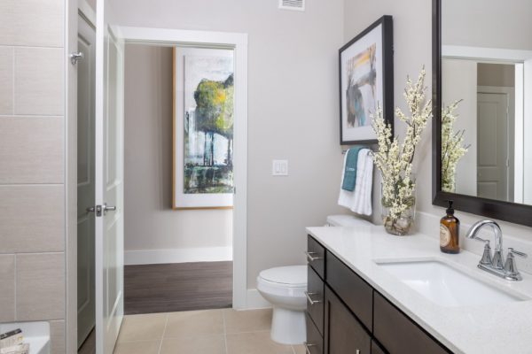 Bathroom with Ceramic Tile Flooring, large vanity, toilet, and shower bath