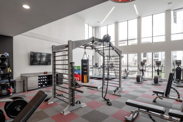 Fitness Center with cardio and strengthening equipment including treadmills, rowing machines, ellipticals, free weights, Individual Weight Machines, and Cage Studio Station with Boxing Bags and Battle Ropes