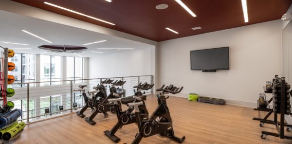 Lofted cycling studio with four stationary bikes and additional strengthening equipment