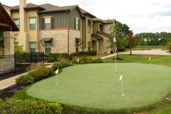 Putting green with clubhouse and apartment buildings in the background